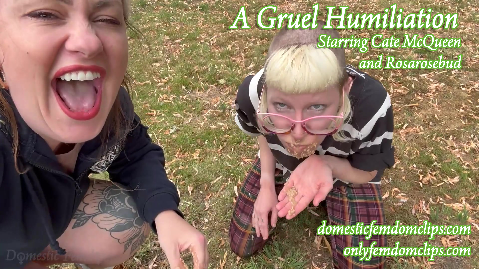 Two people outdoors on grass: one person kneels, holding food in their hands near their mouth, wearing glasses and striped shirt; another person beside them is laughing. Text overlays promote a video titled A Gruel Humiliation.