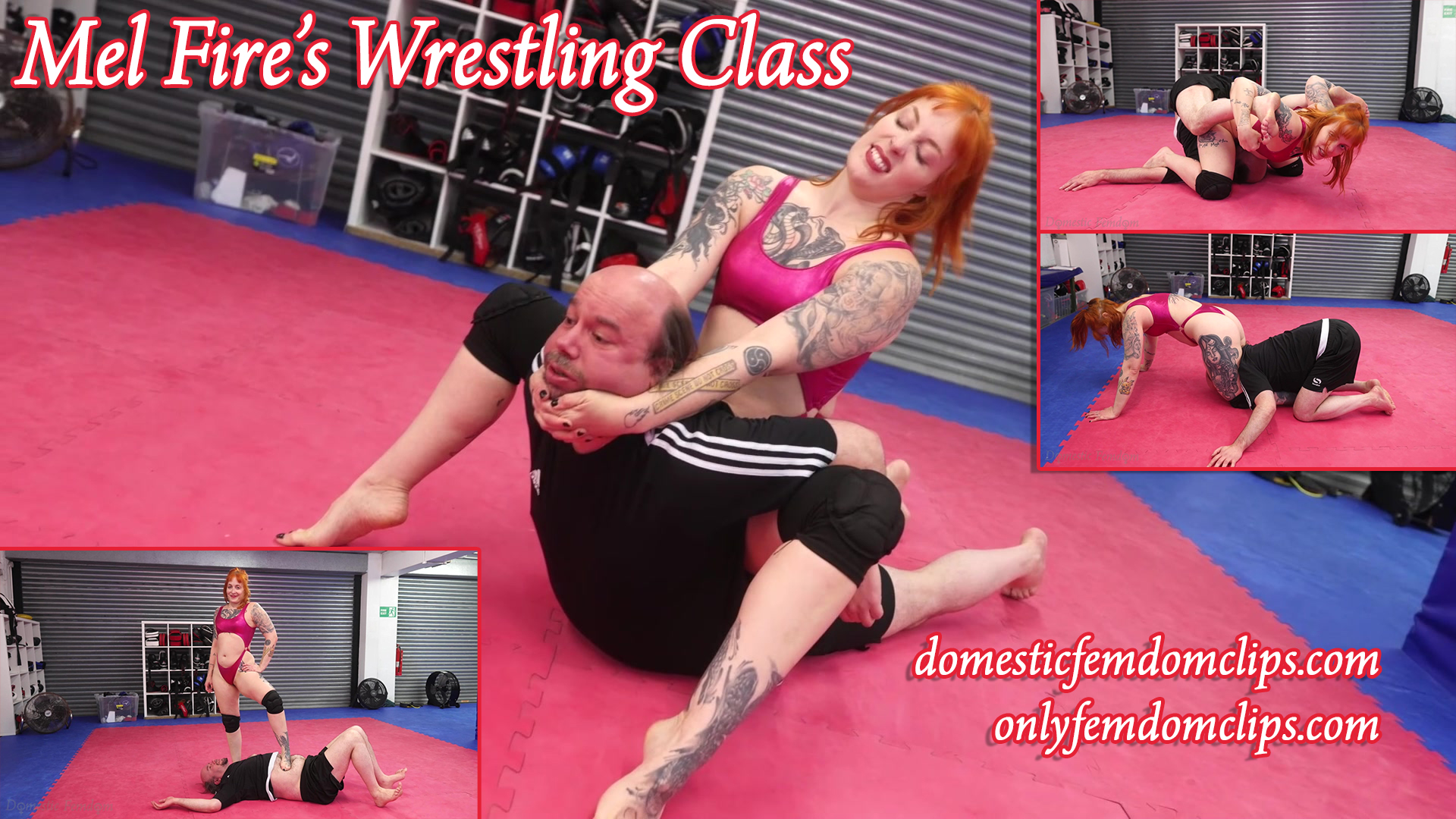 A strong redheaded woman is wrestling a weak submissive man. She has him in a camel clutch